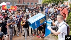 ARSIP – Pengunjukrasa nasionalis kulit putih, kanan, bentrok dengan pengunjuk rasa tandingan saat ia melemparkan kotak surat kabar di jalan masuk ke Lee Park di Charlottesville, Va (foto: AP Photo/Steve Helber, Arsip)
