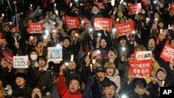 Protesters shout slogans during a rally calling for impeached President Park Geun-hye's arrest in Seoul, South Korea, March 10, 2017. The signs read "Park Geun-hye's arrest." (AP Photo/Ahn Young-joon)