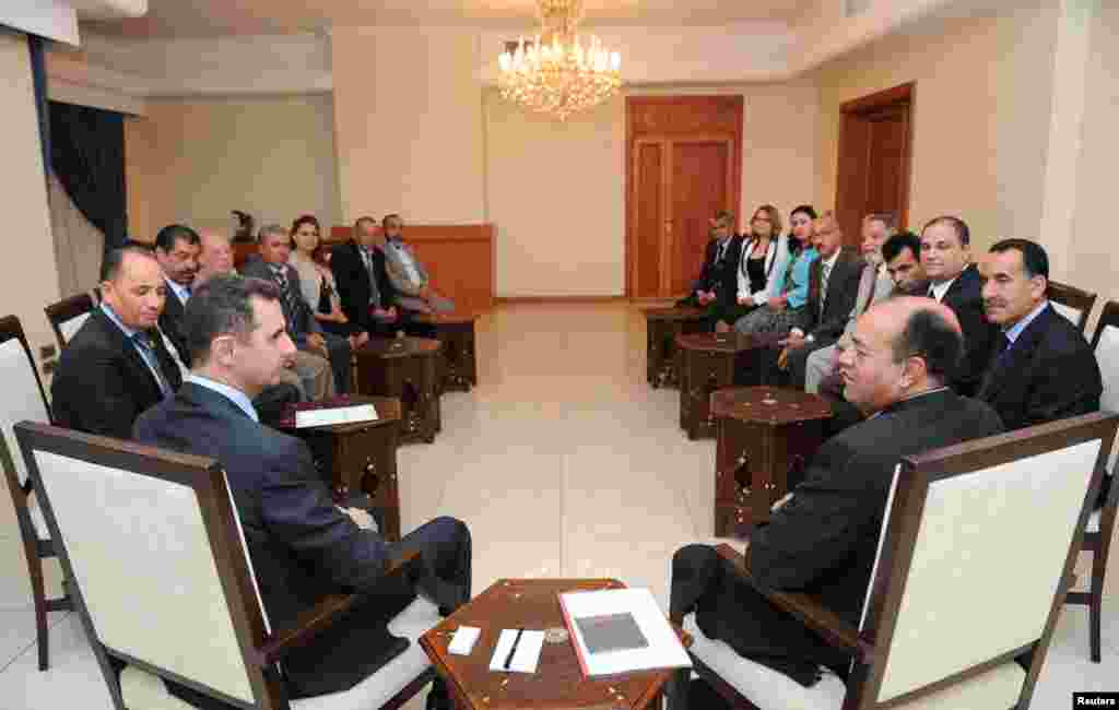 Syria's President Bashar al-Assad (L) speaks with Shukri Bin Suleiman Harmasi (R), secretary general of the Tunisian Immutable Principles Party, during a meeting in Damascus, May 23, 2013.