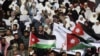 Protesters from opposition parties hold flags and signs during a demonstration against the government's decision to lift fuel subsidies, in Amman, Jordan, November 19, 2012.