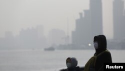 中國霧霾嚴重，1月19日在上海一名市民戴上口罩。