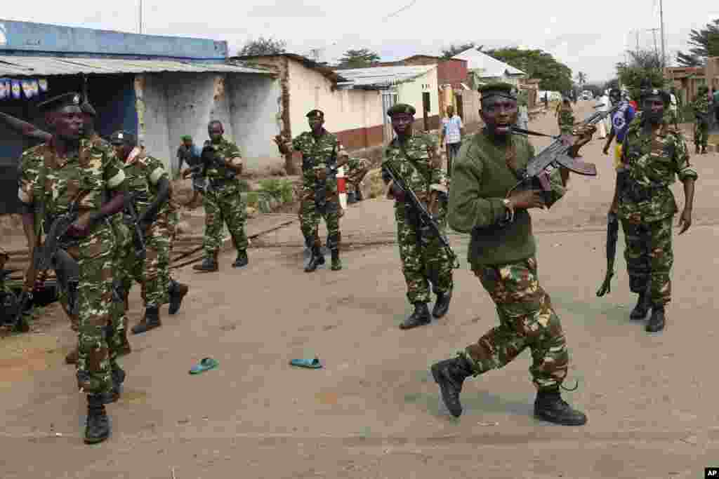 Des soldats tirent en l'air pour disperser des manifestants qui ont acculé Jean Claude Niyonzima un membre présumé de la milice Imbonerakure de la jeunesse du parti au pouvoir dans un égout dans le quartier de Cibitoke de Bujumbura, au Burundi, jeudi 7 mai 2015.