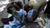Thai policemen check the scene following an explosion near a camp of anti-government protesters at the Victory monument in central Bangkok, Jan. 19, 2014. 