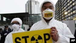 A Greenpeace activist holds a placard during a demonstration outside Japan's Prime Minister Yoshihiko Noda's official residence in Tokyo, criticizing the government's declaration of cold shutdown at the Fukushima nuclear power plant, December 16, 2011.