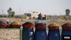Peshmerga soldiers pull out after purchasing olives formerly only available to IS militants, because local people could not afford the luxury under their rule on Nov. 23, 2016. (H.Murdock/VOA)