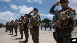 Soldados en la base de la fuerza aérea en Ciudad de Guatemala saludan la llegada de los restos de tres de sus camaradas que murieron en enfrentamientos con presuntos narcotraficantes. AP/Moisés Castillo. Septiembre 5 de 2019. AP