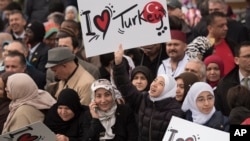 Pengunjung membawa papan bertuliskan dukungan kepada Presiden Turki Recep Tayyip Erdogan dalam peresmian Diyanet Center of America di Lanham, Maryland (2/4).