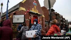 People receive free food from the United Sherpa Association's weekly food pantry on Friday, January 15, 2021, in Queens, New York. (AP Photo/Jessie Wardarski)