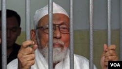 Abu Bakar Ba'asyir berbicara kepada wartawan dari balik jeruji sesaat sebelum sidangnya, 16 Juni silam.