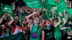 Wanaounga mkono utoaji mimba wakishuhudia kikao cha Bunge kikiendelea kujadili mswaada wa utoaji mimba kupitia televisheni, Buenos Aires, Argentina,Jumatano, Dec. 30, 2020. (AP Photo/Natacha Pisarenko)