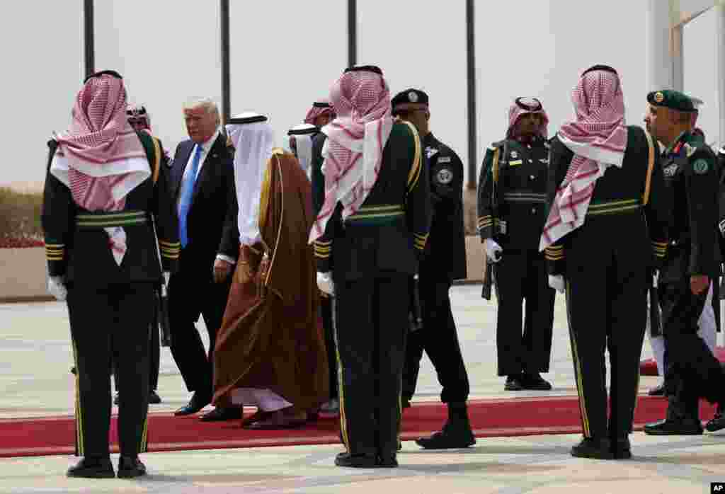 Le président Donald Trump, à l’arrière, et le roi saoudien Salman marchent au milieu d’une haie d’honneur de la garde royale à l’aéroport international roi Khalid, Ryad 20 mai 2017.
