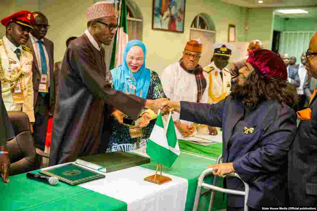 Shugaba Muhammadu Buhari yana bude Cibiyar Ayyukan Shige da Ficen Baki ta Najeriya tare da karamar jakadiya Mrs Uche Ajulu-Okeke da mai rikon mukamin babban jakadan Najeriya a Afirka ta Kudu, Mr. Martins Cobham a lokacin da ya gana da al'ummar Najeriya a karamin ofishin jakadancin Najeriya na Johannesburg a Afirka ta Kudu.