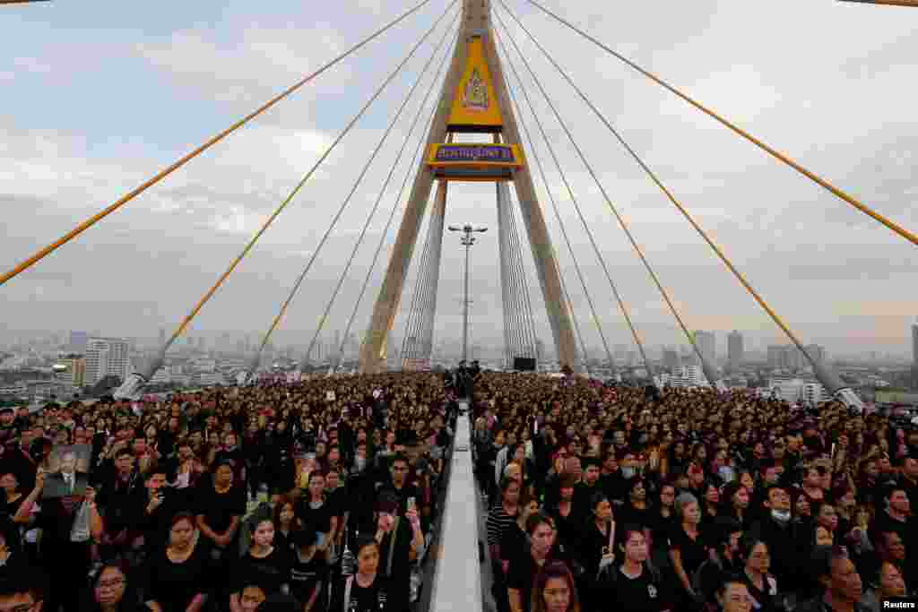 Warga Thailand berkumpul di jembatan Bhumibol di atas sungai Chao Phraya di Bangkok, Thailand, untuk memperingati hari lahir mendiang Raja Bhumibol Adulyadej.