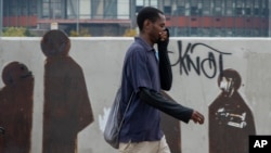 Un homme se couvre le nez et la bouche dans le centre-ville de Johannesbourg, Afrique du Sud, le 16 mars 2020.