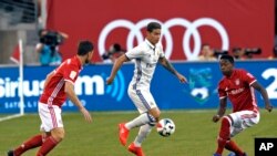James Rodriquez du Real Madrid contrôle le ballon entre deux joueurs du Bayern, Xabi Alonso, à gauche, et David Alaba, lors d’un match amical de football, à East Rutherford, New Jersey, 3 août 2016.