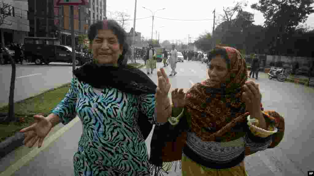 Pakistani women run following an apparent suicide bombing in Lahore, Pakistan, Tuesday, Feb. 17, 2015.
