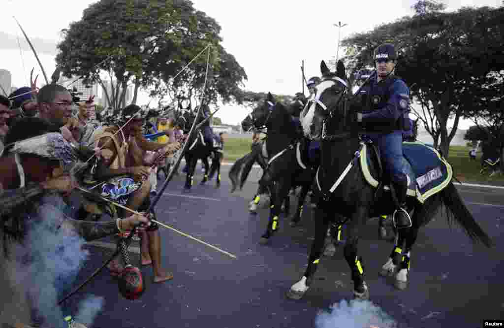 Polisi Brazil menghadang warga suku asli Brazil yang hendak menuju stadion Mane Garrincha dalam demonstrasi anti Piala Dunia di kota Brasilia.