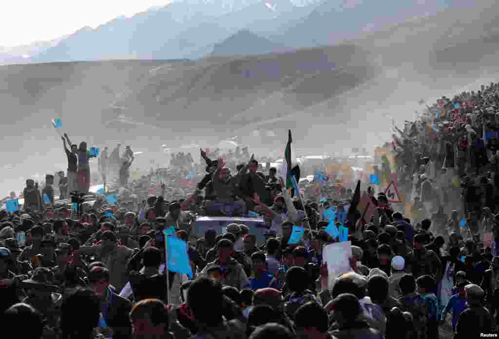 Kandidat presiden Abdullah Abdullah, duduk di atas kendaraan, tiba pada kampanye pemilihan umum di provinsi Panjshir (31/3). (Reuters/Ahmad Masood)