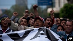 Protesters shout as they protest during a massive march in Mexico City, Thursday, Nov. 20, 2014.