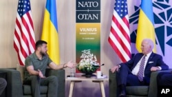 El presidente de Ucrania, Volodymyr Zelenskyy, a la izquierda, y su homólogo de Estados Unidos, Joe Biden, conversan durante un encuentro en los márgenes de la cumbre de la OTAN en Vilna, el 12 de julio de 2023.