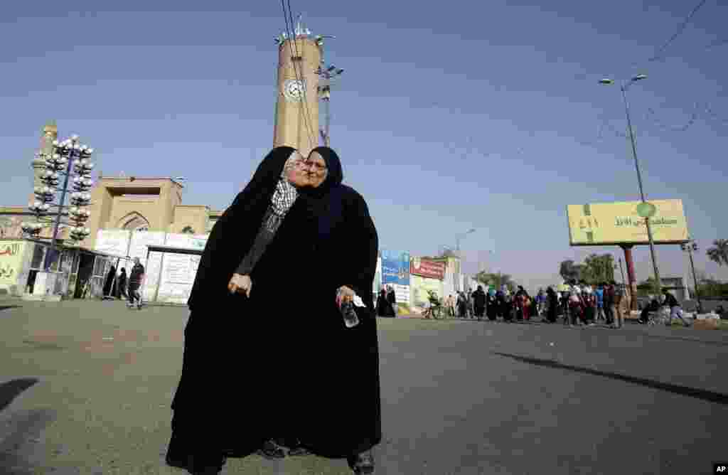 Iraqi Muslims exchange greetings after the Eid dawn prayers outside the Abu Hanifa mosque in the Azamiyah area of north Baghdad, August 8, 2013.