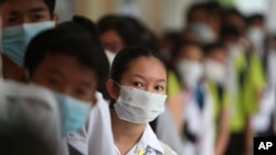 Des étudiants de Phnom Penh ,au Cambodge, font la queue pour se désinfecter les mains pour éviter de contracter le coronavirus, le mardi 28 janvier 2020. (Photo AP / Heng Sinith)