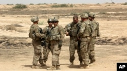 FILE - U.S. soldiers are seen with Iraqi troops, outside Baghdad, Iraq, May 27, 2015. 