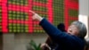 FILE - An investor gestures in front of the stock price monitor at a private securities company in Shanghai, China. 