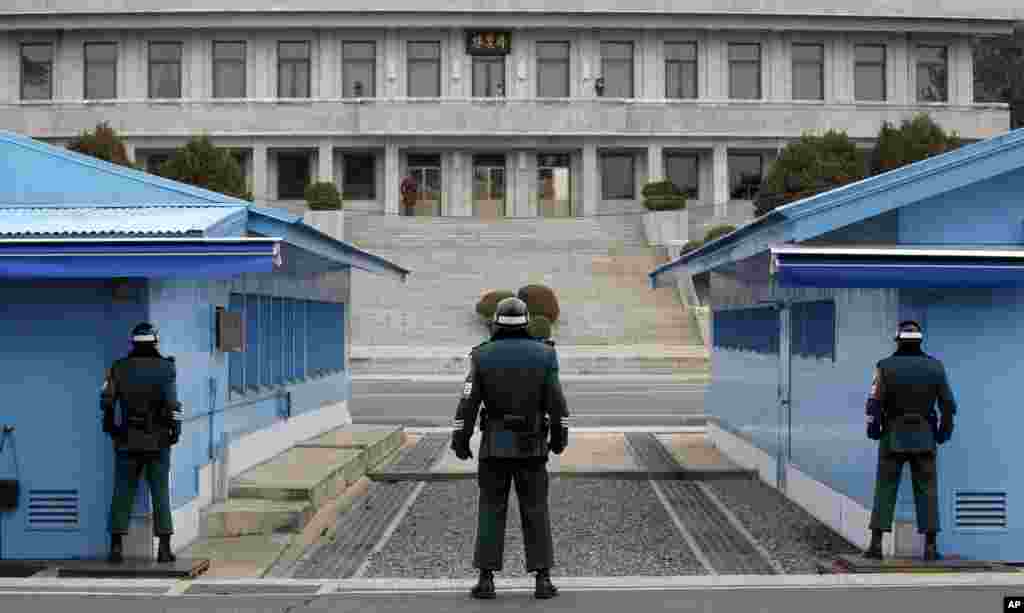 A N. Korean soldier (top center) looks at the southern side as three S. Korean soldiers guard at the border village of Panmunjom, which has separated the two Koreas since the Korean War, in Paju, S. Korea.