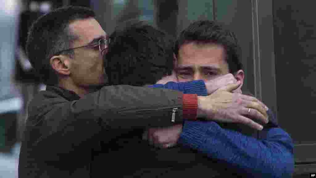 Des membres de famille de passagers qui étaient dans l'avion qui s'est écrasé mardi dans les Alpes françaises avec 150 personnes à son bord, s’étreignent en se consolant.
