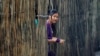 FILE - A refugee who fled Myanmar watches from behind a bamboo wall of a stilt house as Thai authorities conduct a census at Mae La refugee camp, near the Thailand-Myanmar border in Mae Sot district, Tak province, Thailand. Many refugees are hopeful about