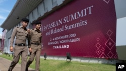 FILE - Thai policemen walk in front of a banner welcoming Association of Southeast Asian Nations in Nonthaburi province, Thailand, Oct. 29, 2019. 