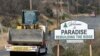 Vehicles pass a sign welcoming people to Paradise, Calif., Nov. 5, 2019. The sign also displays the slogan, "Rebuilding The Ridge," that has become the community's rallying cry since a wildfire devastated the area.