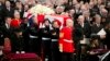 Britain's Queen Elizabeth (front L) and Mark Thatcher (R), son of former British prime minister Margaret Thatcher, watch as her coffin arrives in St Paul's Cathedral for the funeral service, London, April 17, 2013. 