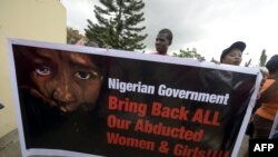 FILE - Members of Bring Back Our Girls movement carry a banner to press for the release of the missing Chibok schoolgirls in Lagos, April 14, 2016.