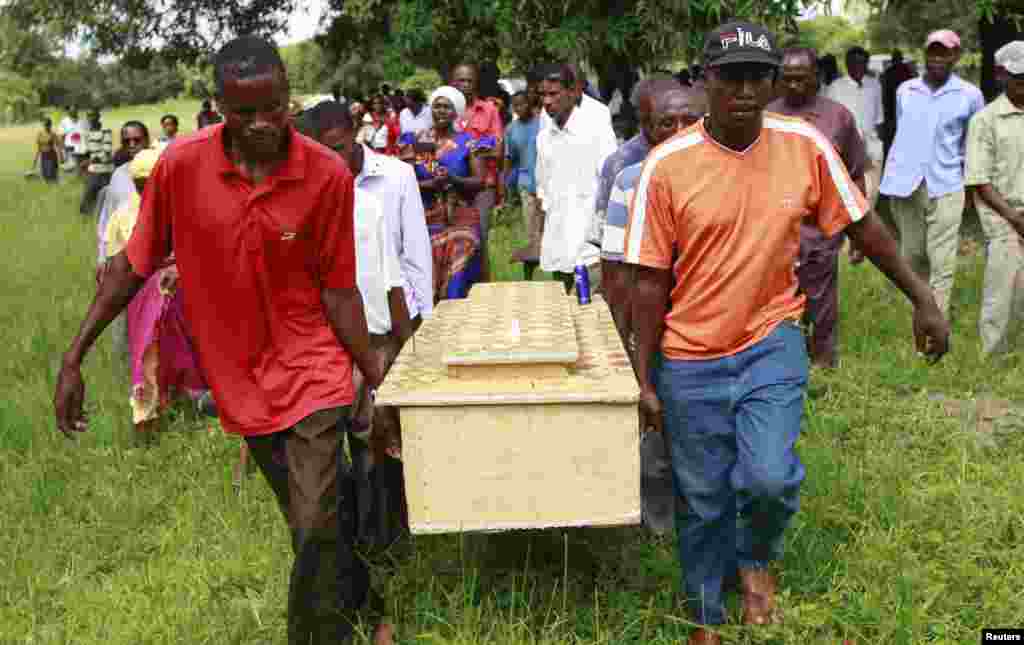 Pallbearers carry a coffin containing the remains of Francis Kamande killed when gunmen attacked the coastal Kenyan town of Mpeketoni, June 18, 2014.