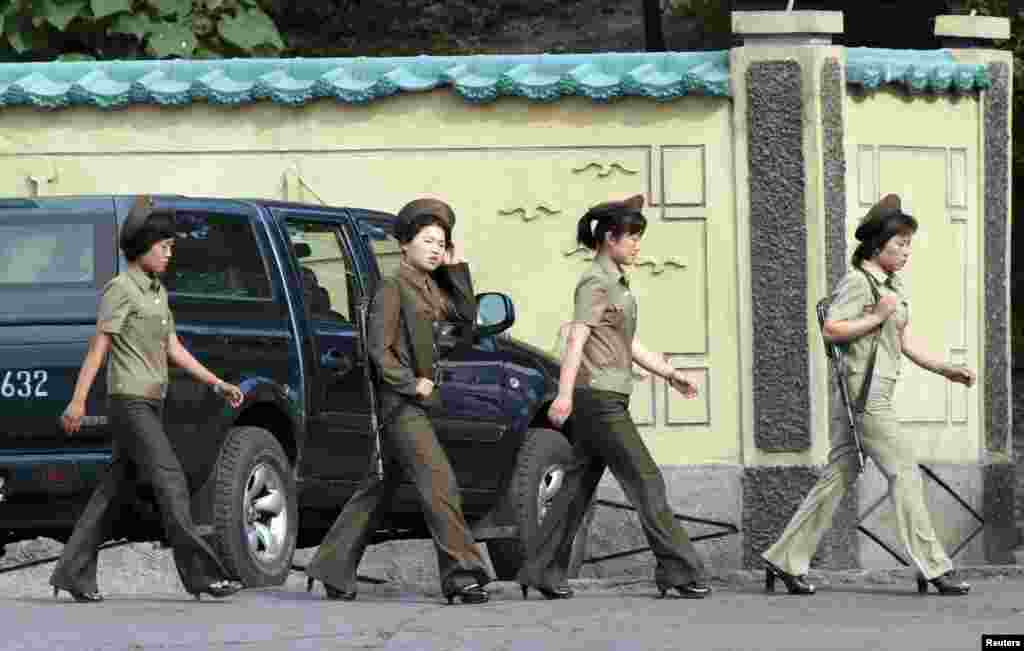 Female North Korean soldiers walk along the banks of the Yalu River near the town of Sinuiju, opposite the Chinese border city of Dandong.