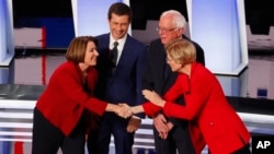 Sen. Amy Klobuchar, D-Minn., from left, South Bend Mayor Pete Buttigieg, Sen. Bernie Sanders, I-Vt., and Sen. Elizabeth Warren, D-Mass., greet each other before the first of two Democratic presidential primary debates hosted by CNN Tuesday, July 30, 2019.
