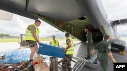 Para petugas memasukkan botol air dan bantuan lainnya ke dalam sebuah pesawat transport logistik milik Angkatan Darat Perancis menuju Vanuatu, di Pangkalan Udara Militer Letnan Paul Klein (sebelumnya dikenal sebagai La Tontouta), sebelah utara Noumea, Kaledonia Baru, 15 Maret 2015. (Foto: dok).