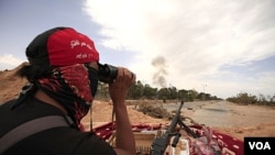 Anggota pasukan pemberontak Libya menggunakan teropong untuk mengamati suasana di kota Misrata.
