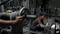 Nizam, 11, works at a factory that makes metal utensils in Dhaka, Bangladesh, June 12, 2016. 