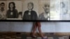A tourist looks at portraits of victims killed in former Khmer Rouge regime's S-21 security prison, presently known as Tuol Sleng Genocide Museum, Phnom Penh, March 5, 2013.