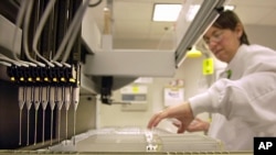 FILE - A technician loads patient samples into a machine for testing at Myriad Genetics, May 31, 2002.