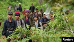 Montagnard hill tribesmen walk towards the main road after emerging from dense forest 70 km (43 miles) northeast of Ban Lung, located in Cambodia's northeastern province of Ratanakiri, file photo. 