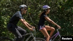 Malia Obama bersepeda bersama ayahnya, Presiden AS Barack Obama, dalam salah satu liburan keluarga di Martha's Vineyard di Massachusetts. (Foto: Dok)