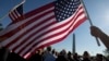 Anggota Marinir AS Terri Shreiner mengibarkan bendera AS dalam pawai di Washington Memorial, menuntut penghentian penutupan sebagian kegiatan pemerintah, di Washington, 15 Oktober 2013.