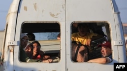 Raseljeni Palestinci sjede pored svojih stvari u kombiju koji se vozi u kampu al-Bureij u centralnom pojasu Gaze 2. juna 2024.