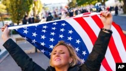 Kelly Janowiak of Chicago, prays with a conservative Christian Evangelical group while holding a American flag, Nov. 2, 2020, in Washington.