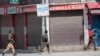 Polisi berlarian di dekat lokasi baku tembak di Sopore, 55 kilometer utara Srinagar, Kashmir yang dikuasai India, Sabtu, 12 Juni 2021. (AP/Mukhtar Khan)