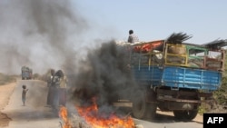 FILE - A truck passes a partial roadblock set up by residents as a protest against al-Shabab insurgents, outside Mogadishu, March 6, 2014.